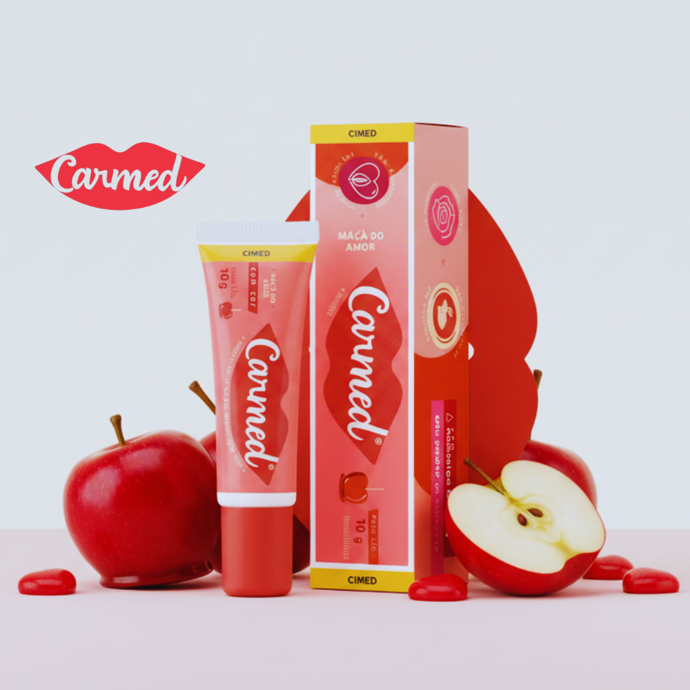 A tube of Carmed Maçã do Amor lip balm with a design featuring green and red apples.