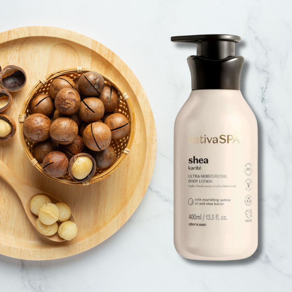 Shea butter lotion bottle next to a wooden bowl with shea nuts on a white background