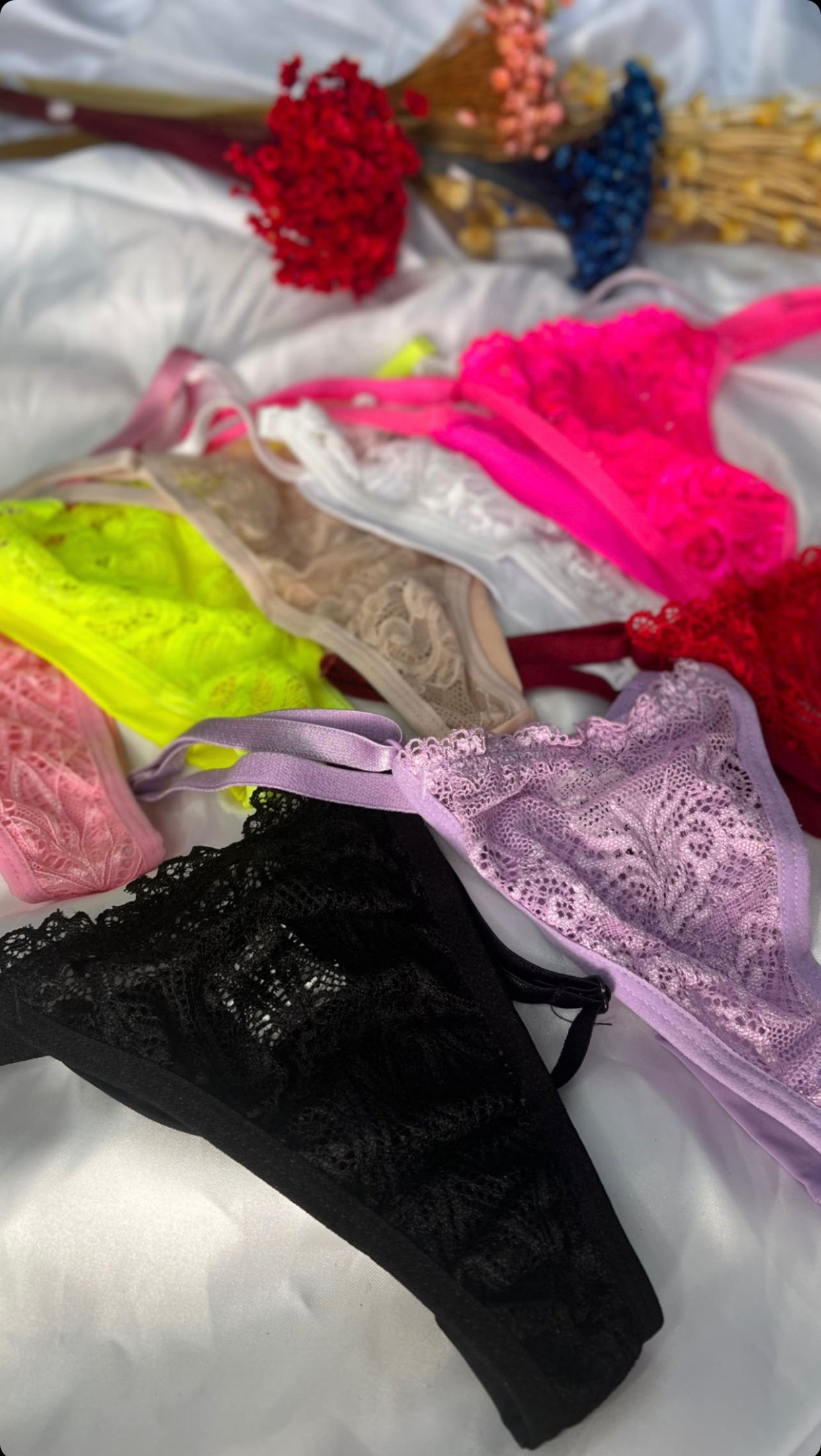 A collection of women's underwear in various colors neatly displayed on a surface, with a focus on the thread panties which are adjustable.
