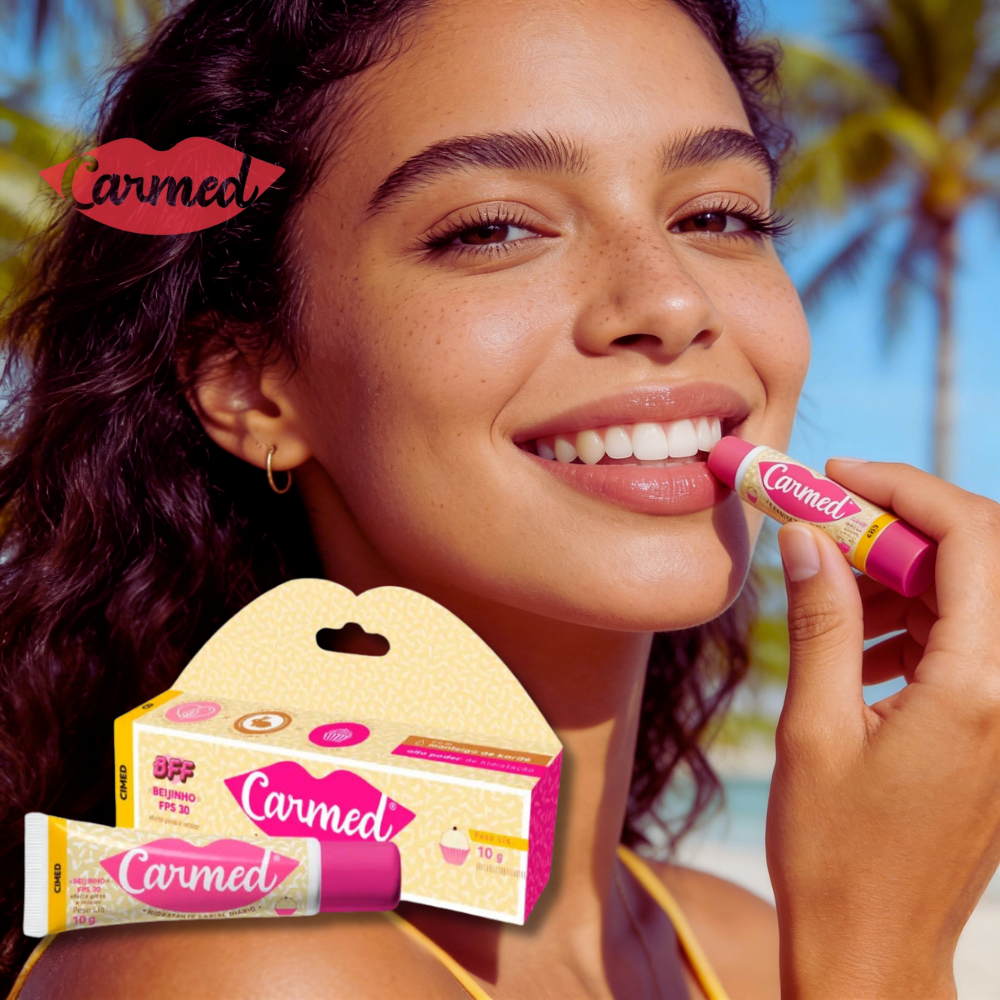A woman holds a tube of Carmed BFF Beijinho 10g, showcasing its colorful packaging and her bright smile
