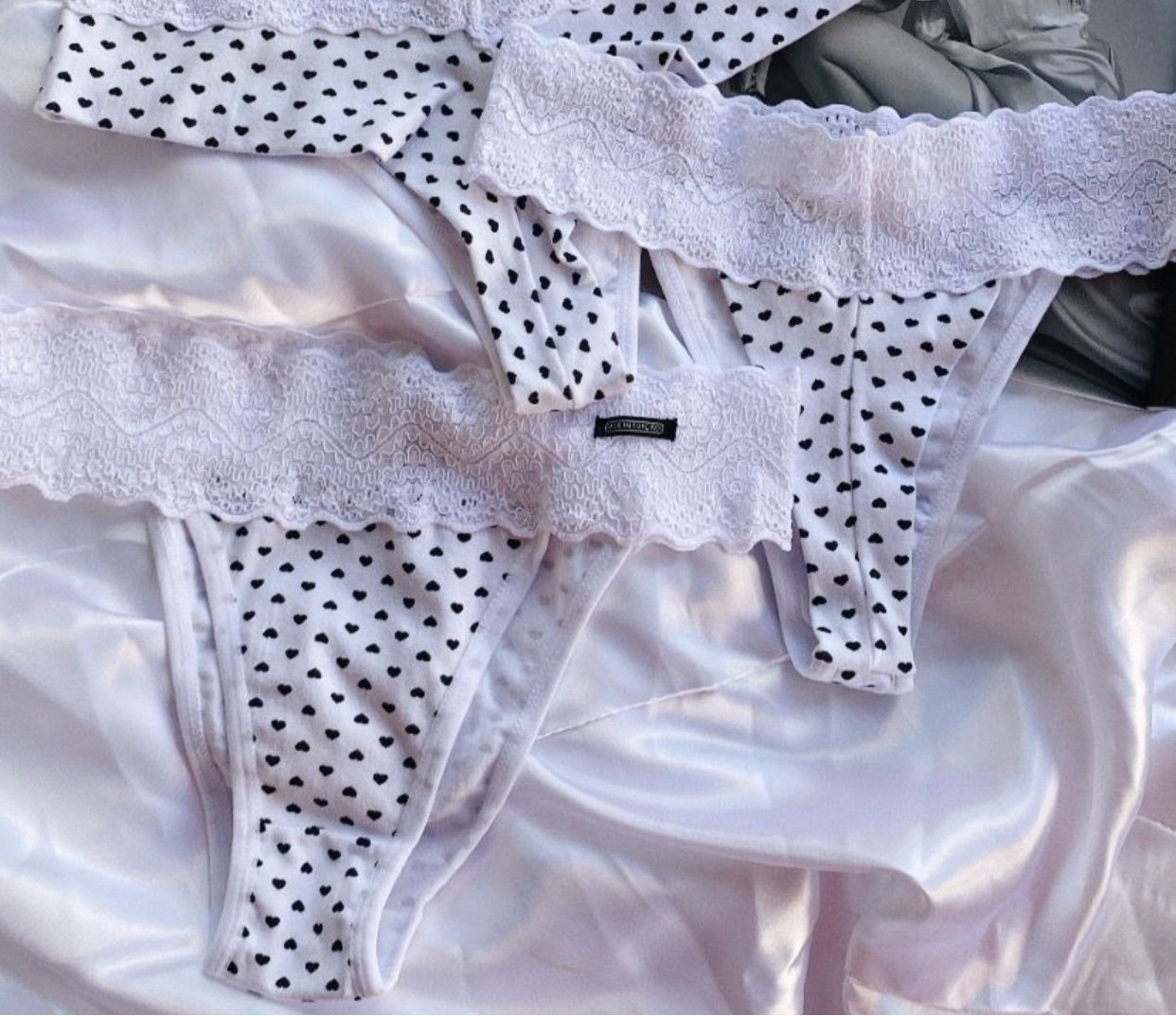 Lace-waist thong panties with a black heart print. 