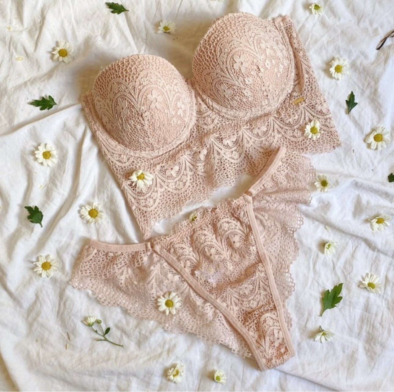 Feature a light pink, unlined or lightly lined lace fabric with a longline bralette design and matching thong or brief-style underwear.