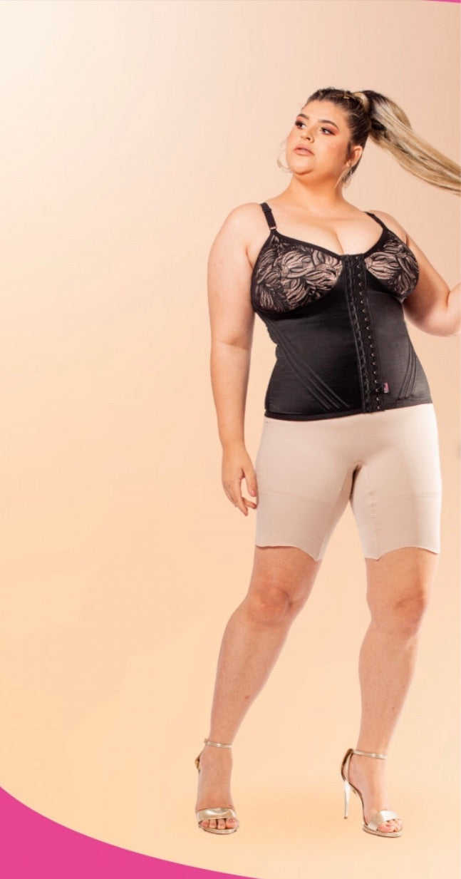 Girl wearing a black lace corset-style shaper top with beige, high compression shorts.